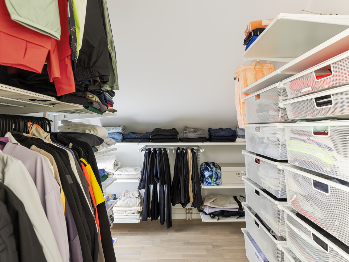 Wardrobe with storage from Classic by Elfa with hanging clothes, pull-out mesh baskets and a pant hanger.