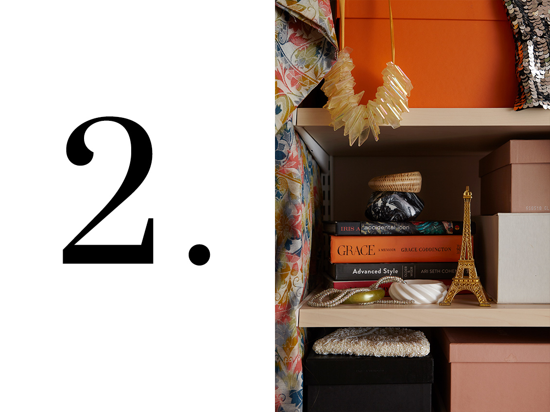 Décor+ by Elfa wardrobe with shelves in birch, containing accessories and books.