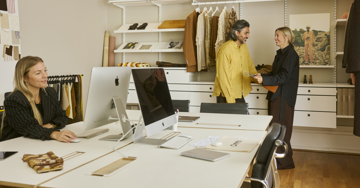 Saif and Emma in their office with an open Décor+ by Elfa wardrobe in white.