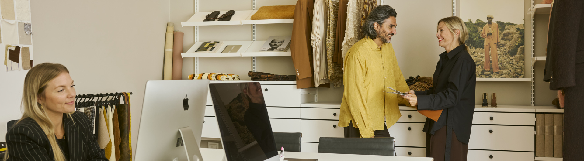 Saif and Emma in their office with an open Décor+ by Elfa wardrobe in white.