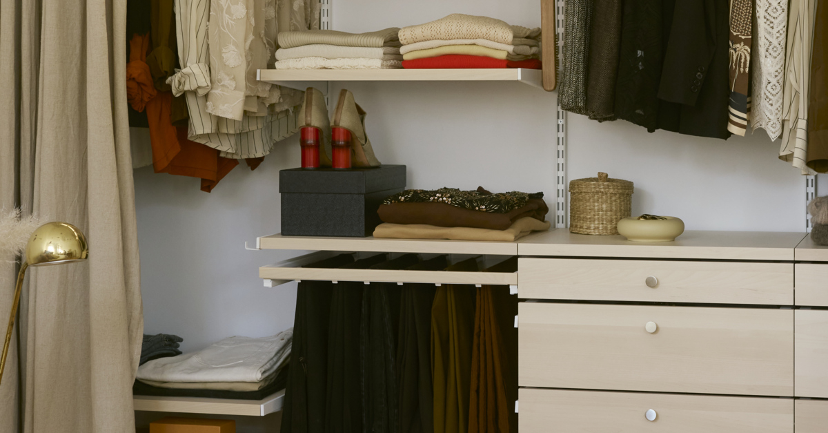 Clothing and accessories in a Classic by Elfa wardrobe in white and birch.