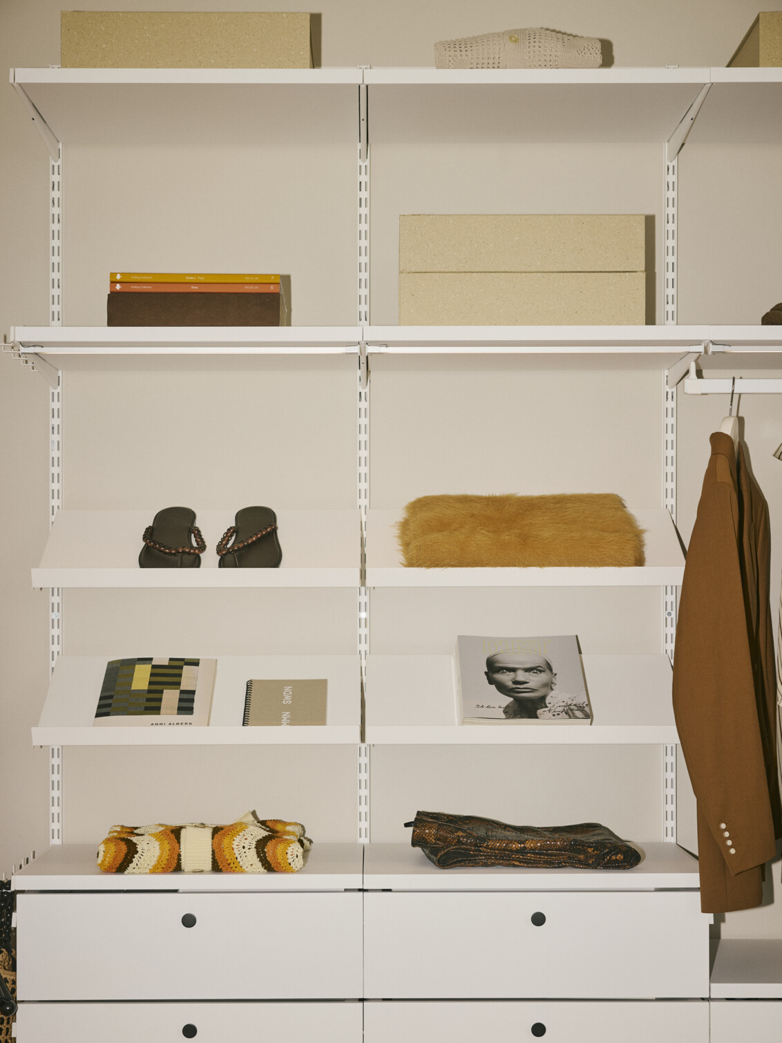 Décor+ by Elfa in white with angled shelves and pull-out drawers.