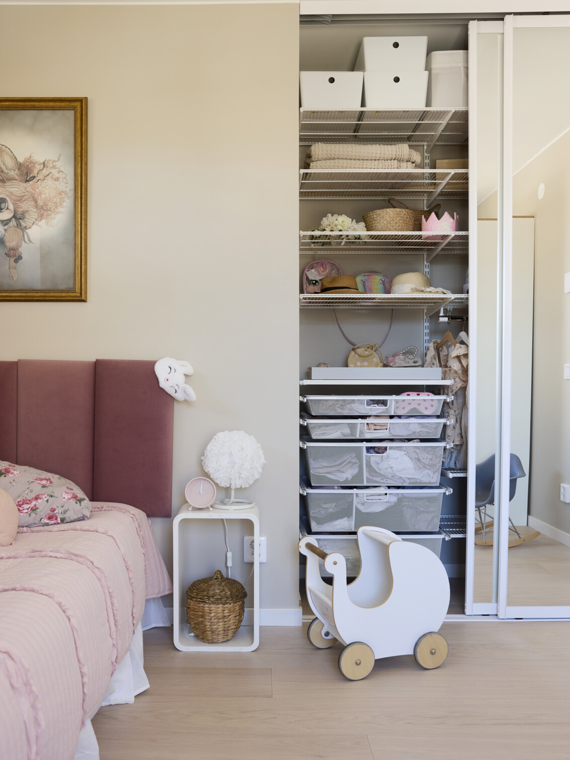Children’s room with wardrobe from Elfa with wire shelves and pull-out mesh baskets in white.