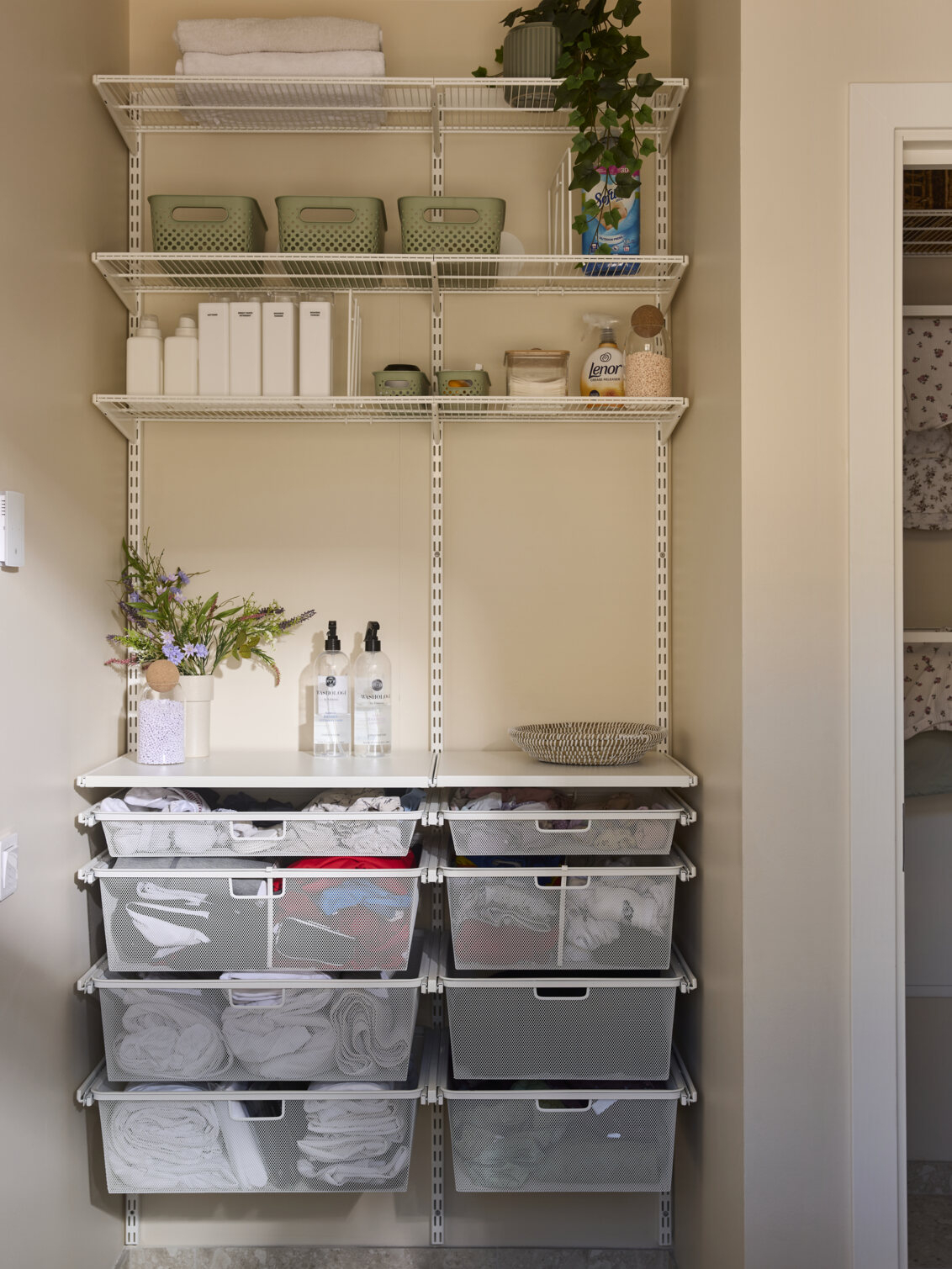 Laundry room with Classic by Elfa storage in white with wire shelves and pull-out mesh bins.