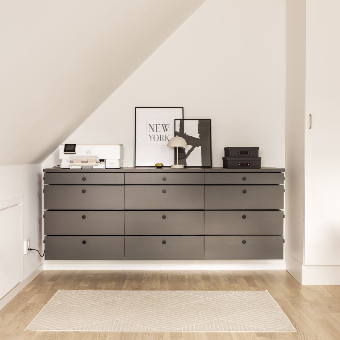 Décor+ by Elfan harmaa lipasto, jonka päällä on koristeita vinokaton alla.