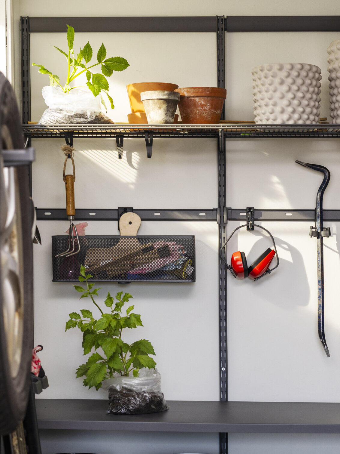 Garage with Garage+ storage from Elfa used to store plants and garden tools.