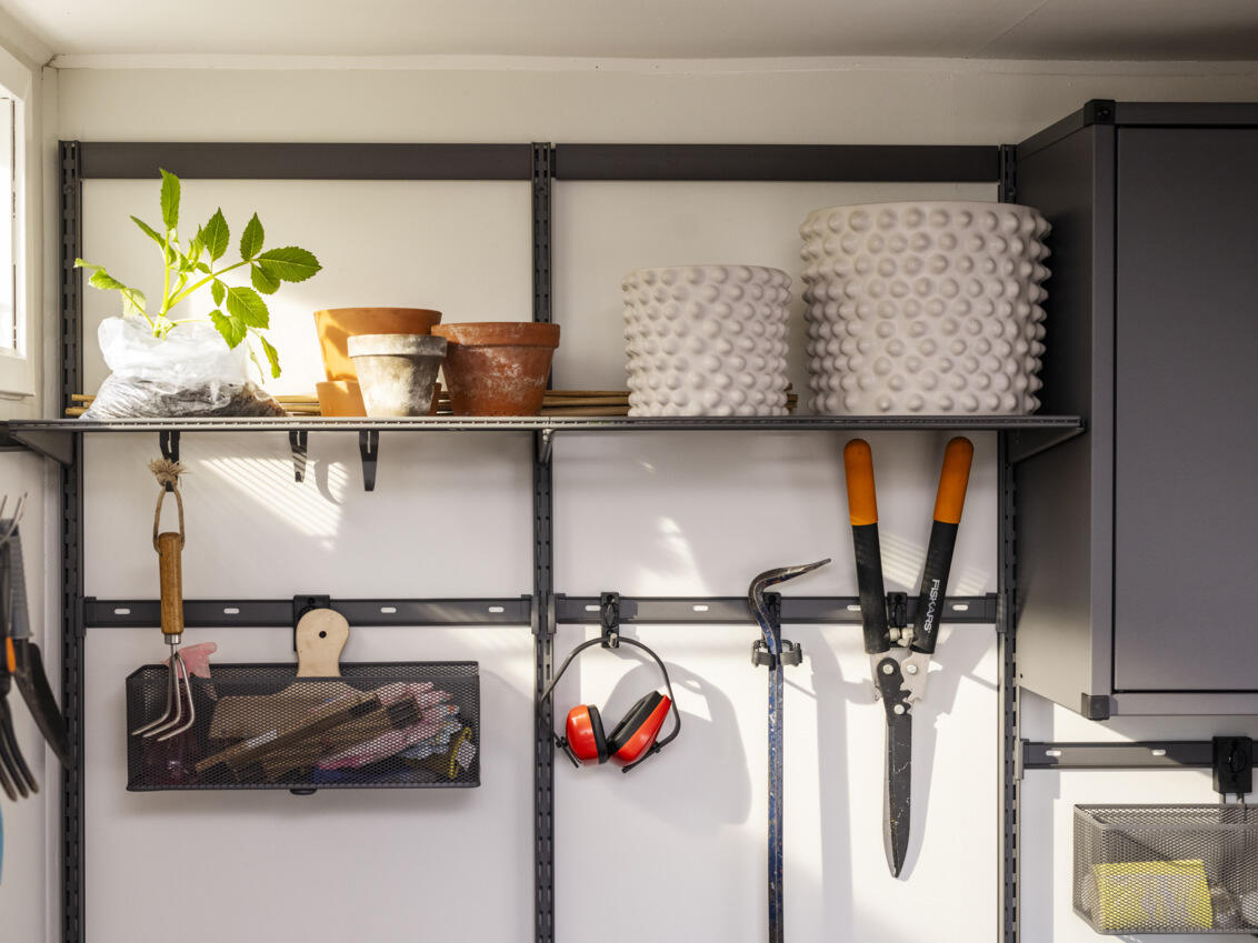 Garage with Garage+ storage from Elfa with wire shelves and storage track for storing pots and garden tools.