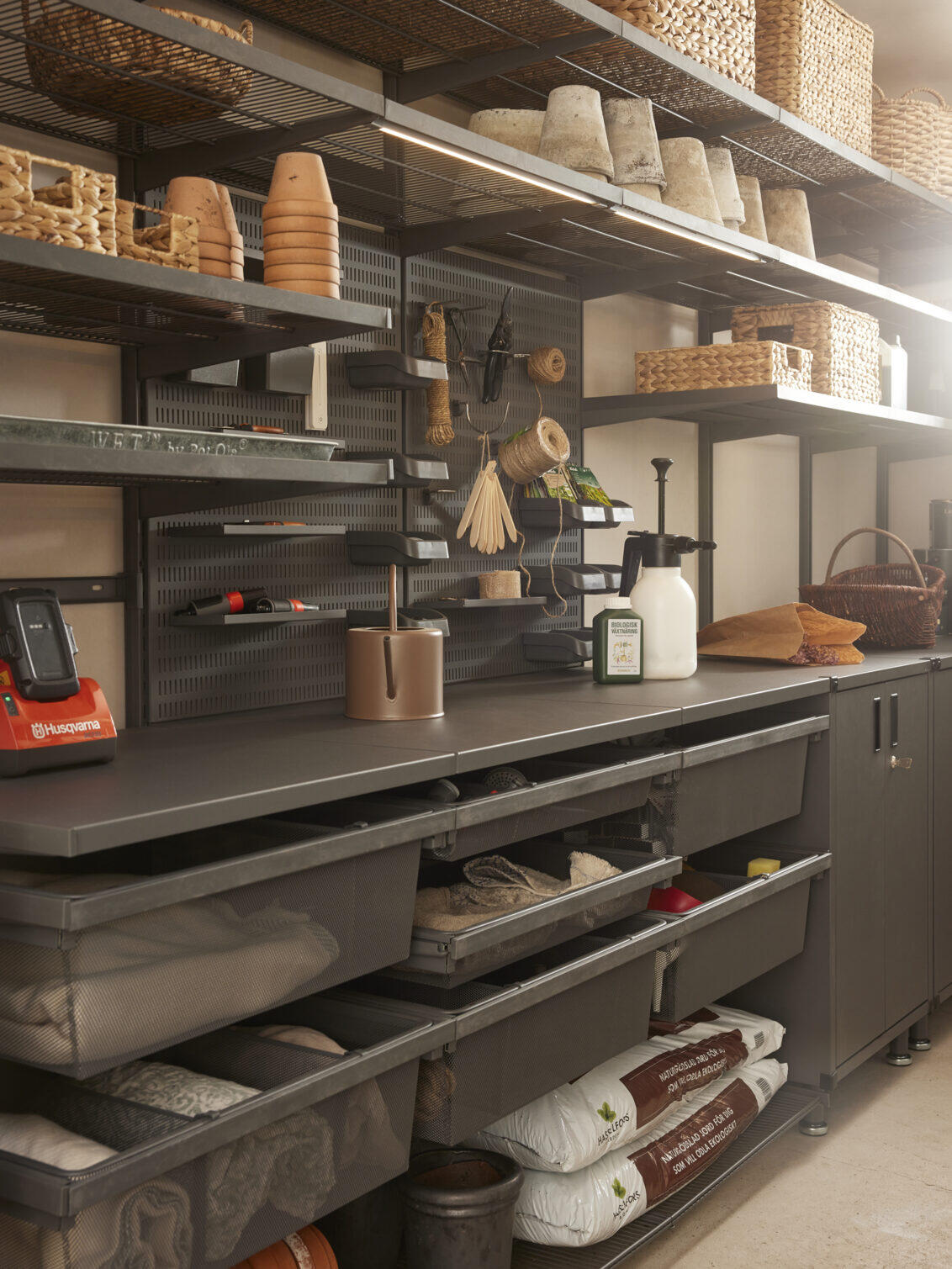 Storeroom with Garage+ storage from Elfa with wire shelves, peg board and drawers for storing baskets and pots.