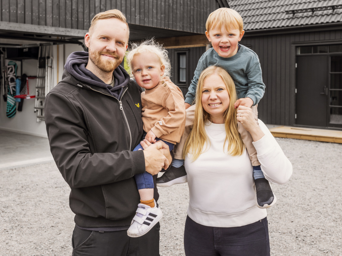The family stands outside their garage.