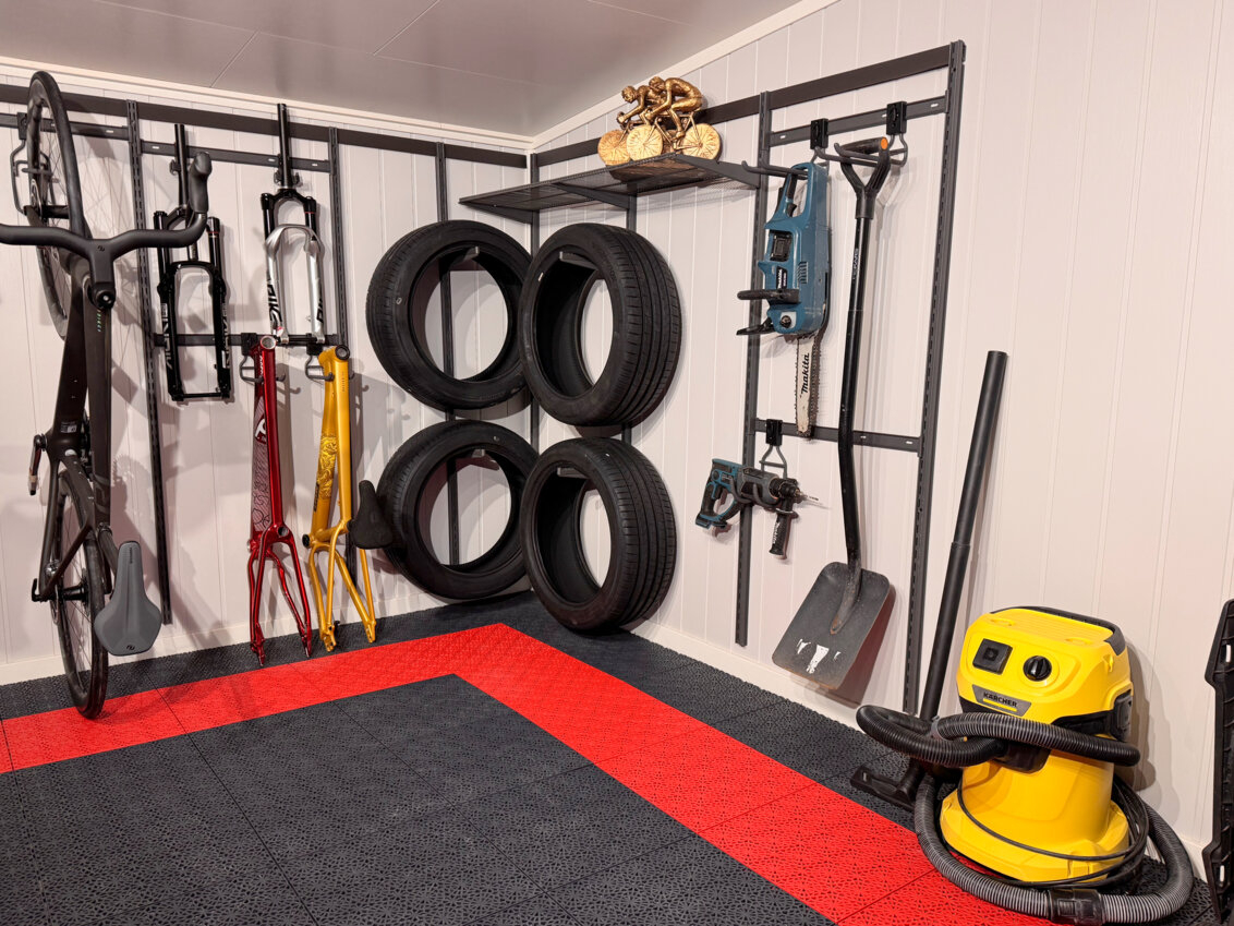 Garage with Garage+ by Elfa storage, where a bike, car tyres and tools hang on the wall.