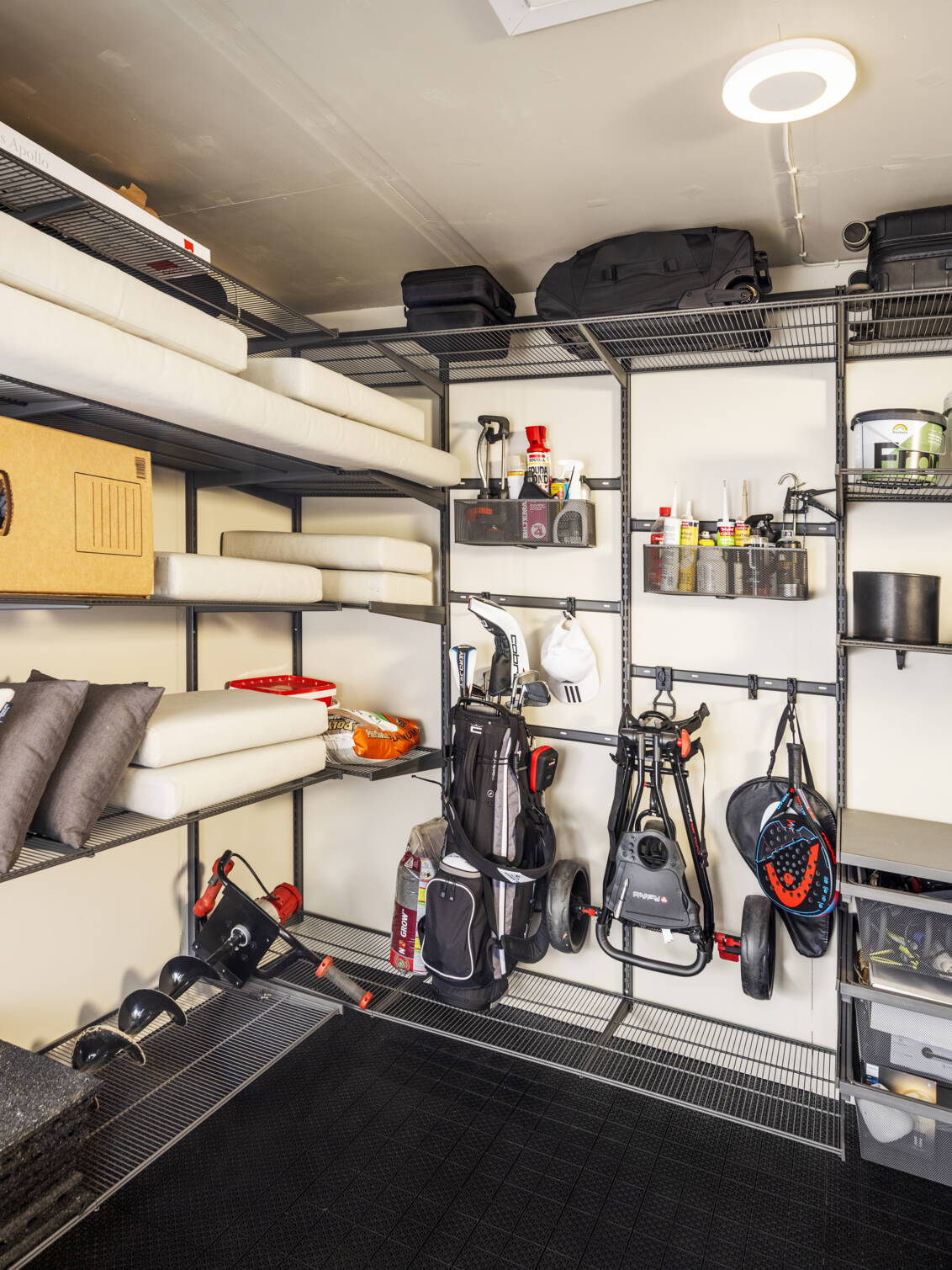 Garage with storage from Garage+ by Elfa where sports equipment and cushions are stored.