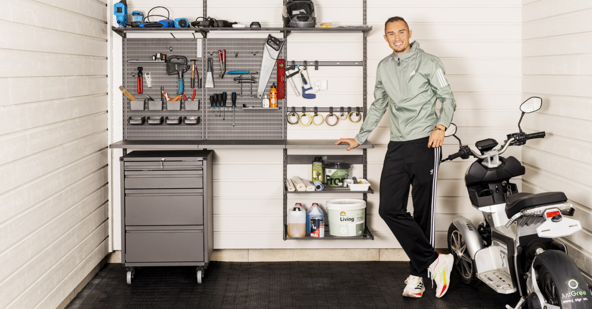 Thobias Montler stands in a garage with storage from Garage+ by Elfa where tools hang.