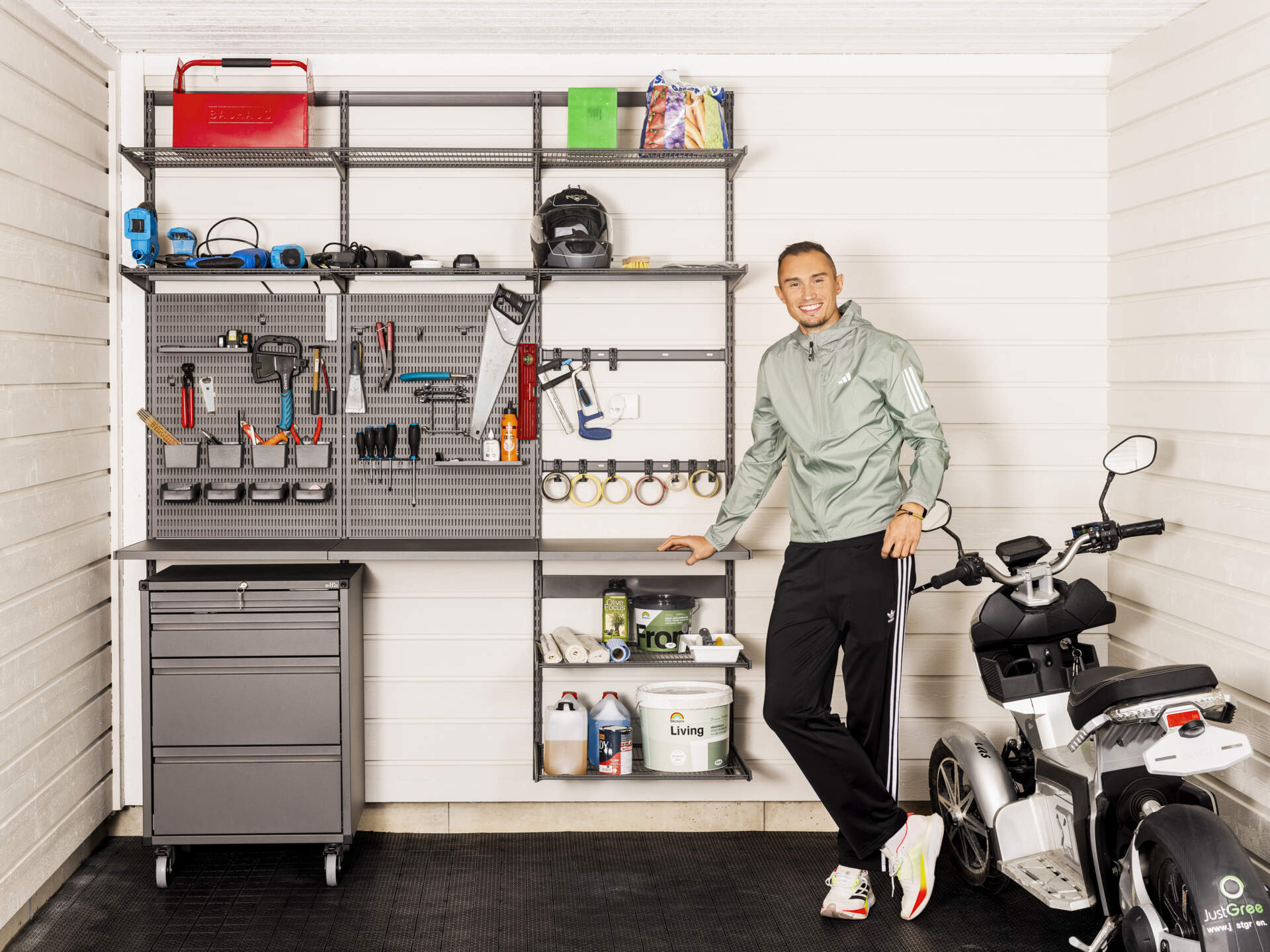 Thobias Montler stands in a garage with storage from Garage+ by Elfa where tools hang.