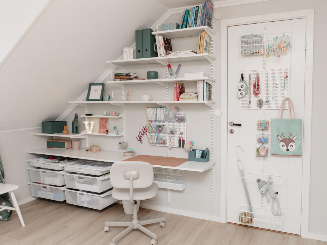 Børneværelse med hylder, skrivebord og døropbevaring fra Elfa under skråvæg.