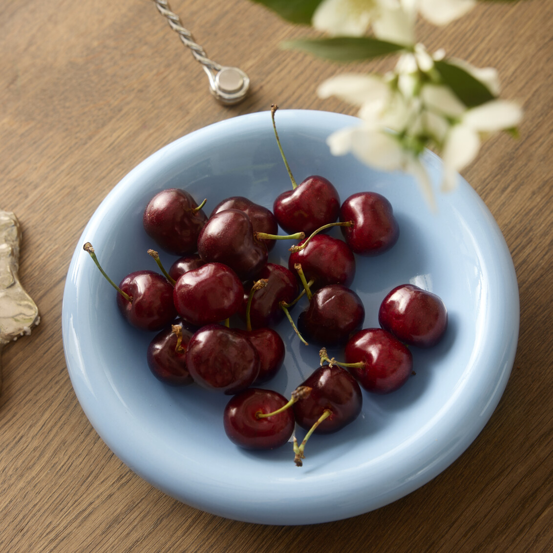 Light blue small plate filled with cherries.
