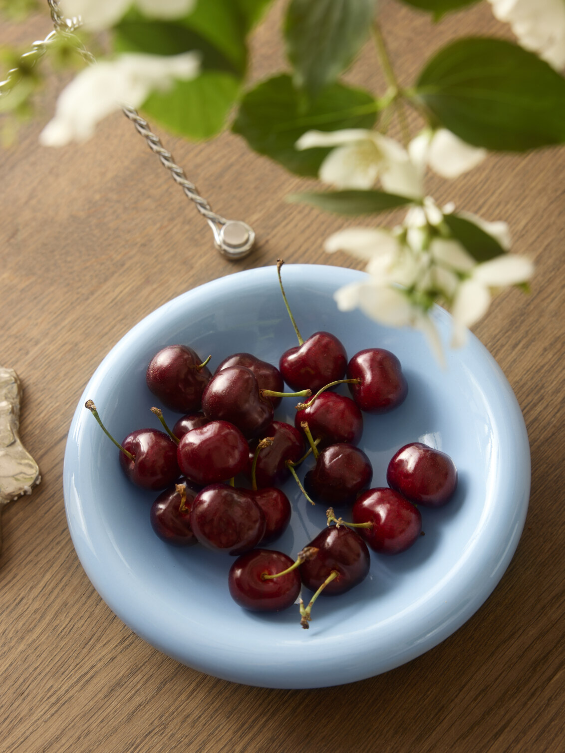 Light blue small plate filled with cherries.