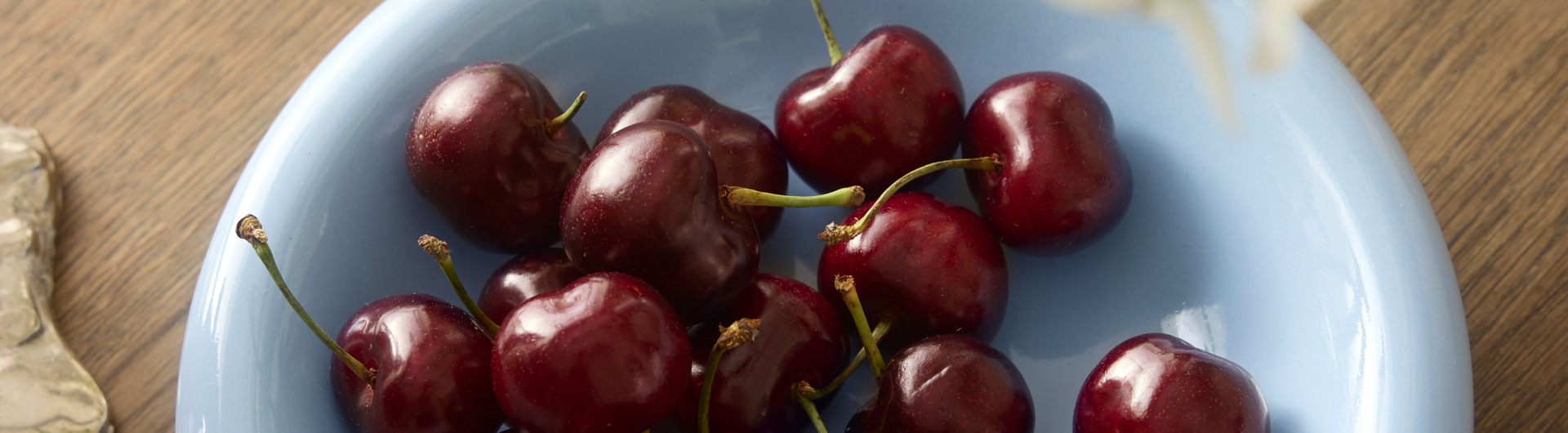 Light blue small plate filled with cherries.