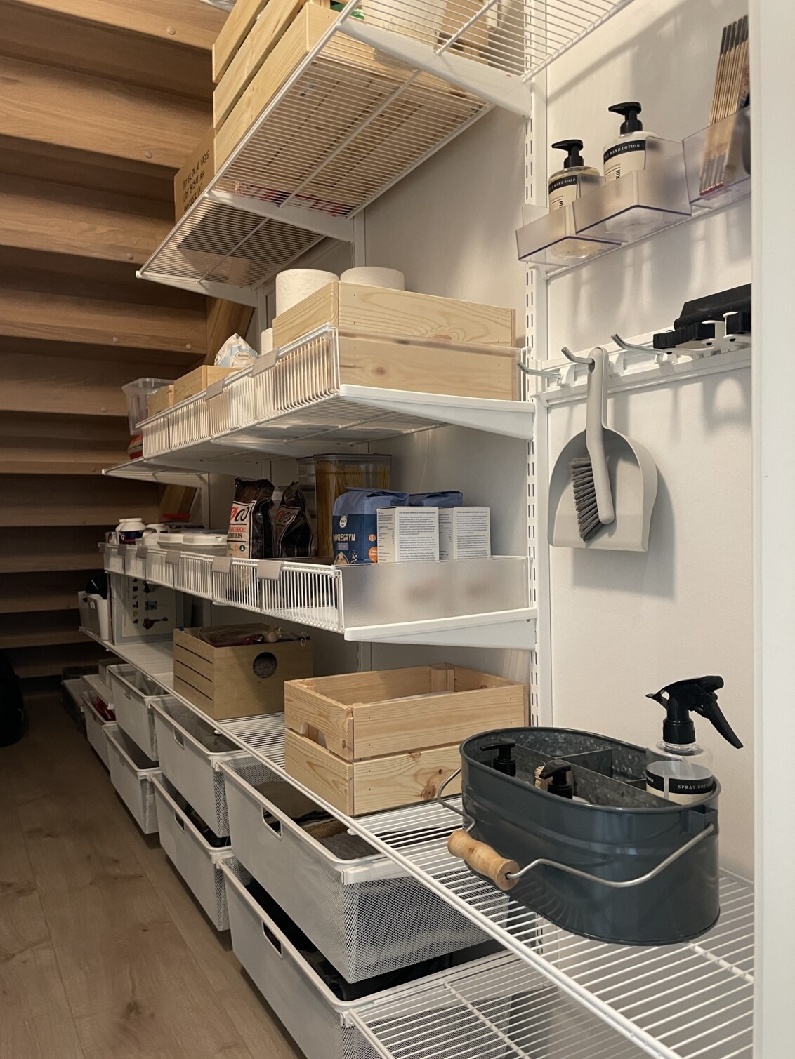 Portaiden alla oleva kaappi, jossa on Elfan säilytystilat kuiville tuotteille ja siivoustarvikkeille.