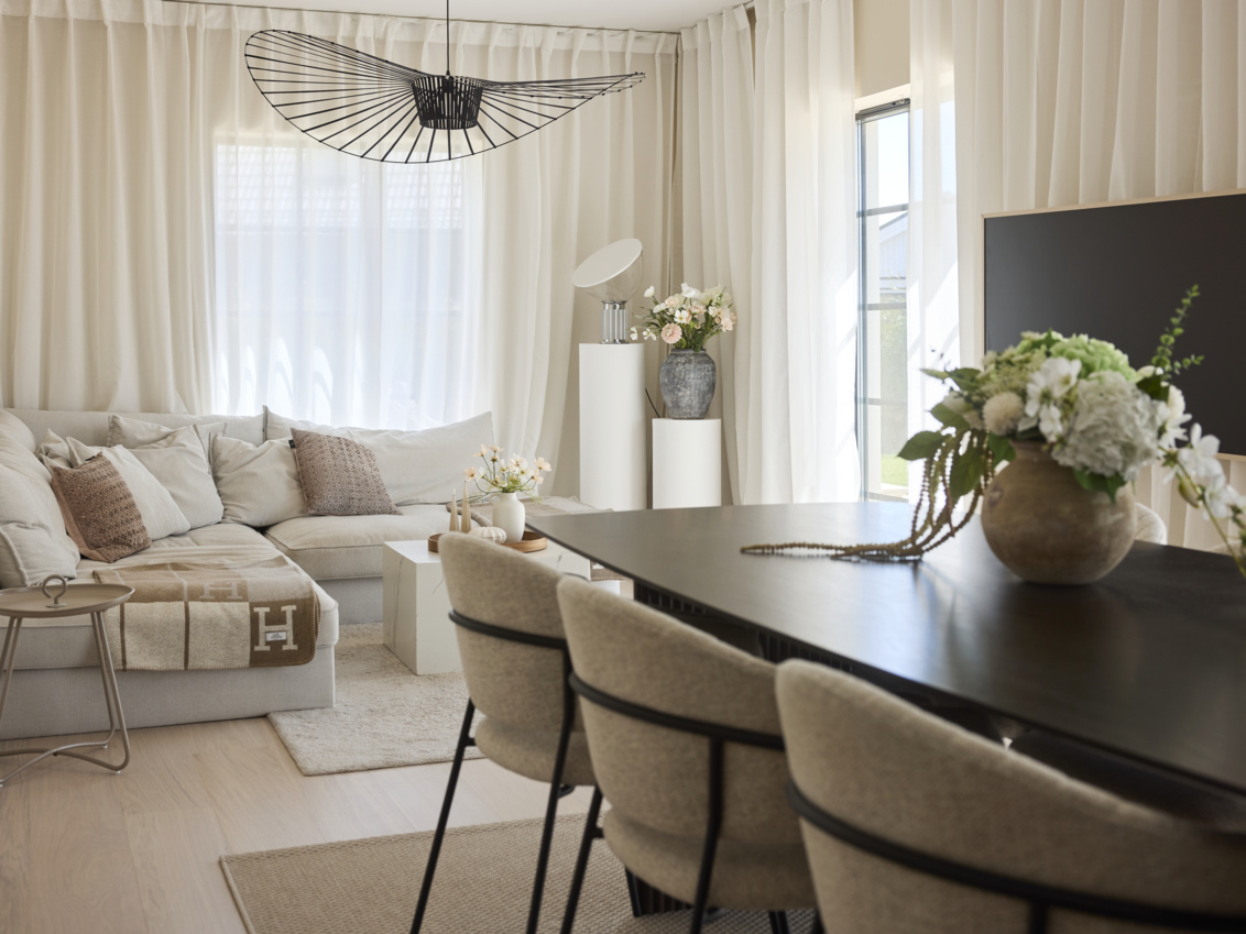 Living room in light tones with dinner table in dark wood.