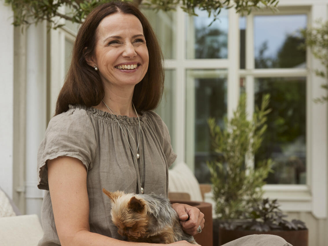 Carin sitting and holding her dog.
