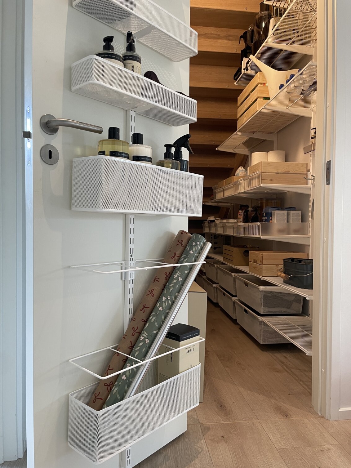 Säilytystila portaiden alla, Elfan säilytystilaa seinällä ja ovessa, jossa säilytetään kuivia tuotteita, siivoustarvikkeita ja lahjapaperia.