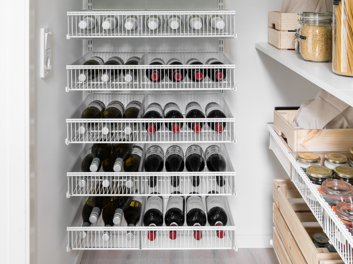 Classic by Elfa -säilytyskalusteet ja lankakorit, joissa on viinipulloja.