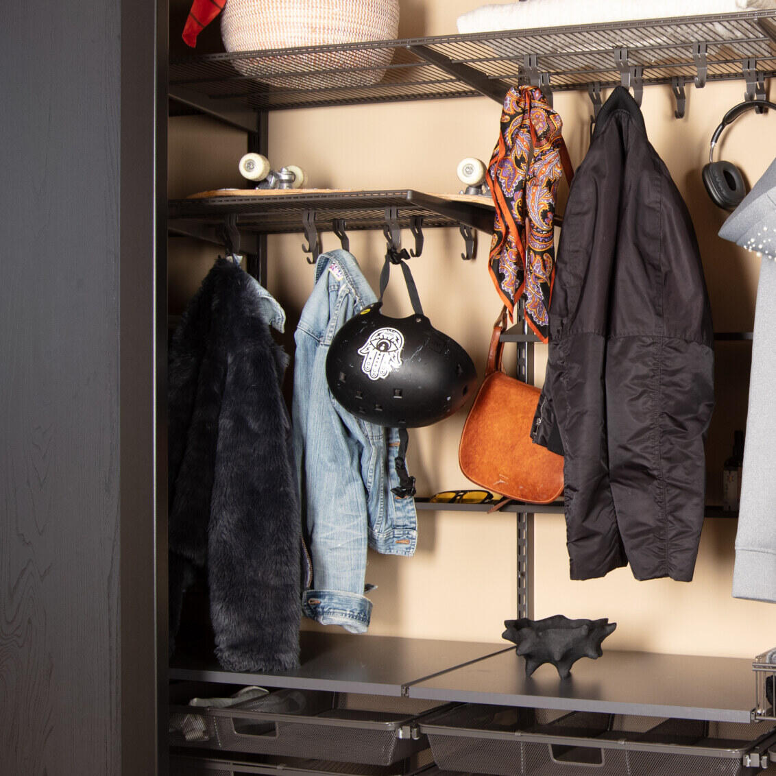 Ganggarderobe fra Elfa med grå innredning, hengende ytterklær og sko samt skyvedørene Grace i svart.  