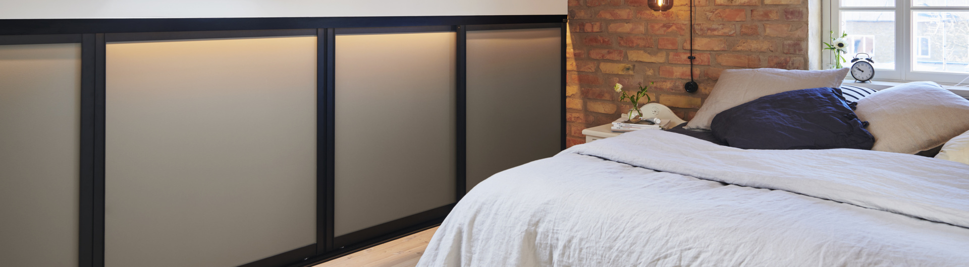 Makuuhuone, jossa on matala vaatekaappi ja liukuovet Elfalta.