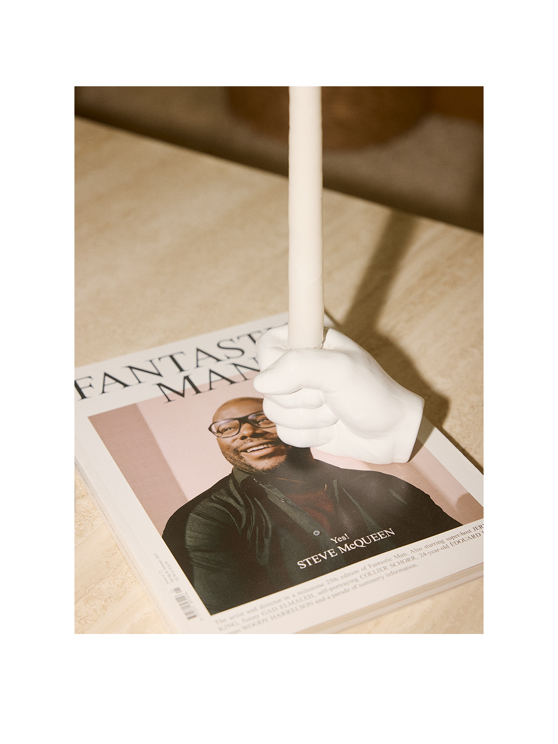 Candlestick on top of a magazine.