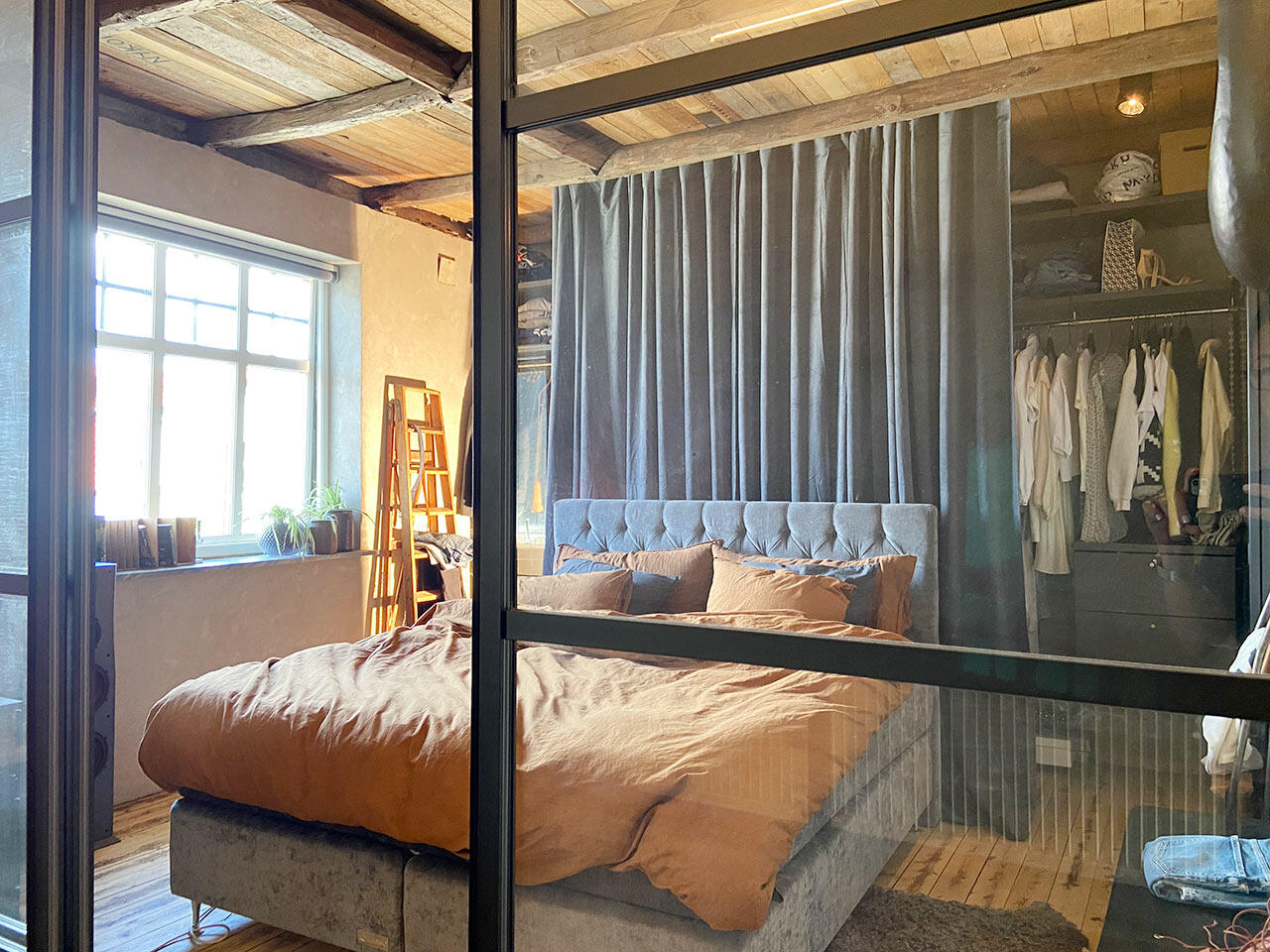 Room divider with black frame and glass filling in bedroom