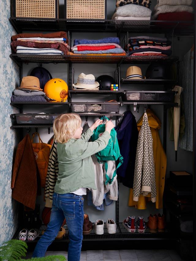 Boy hangs up his clothes