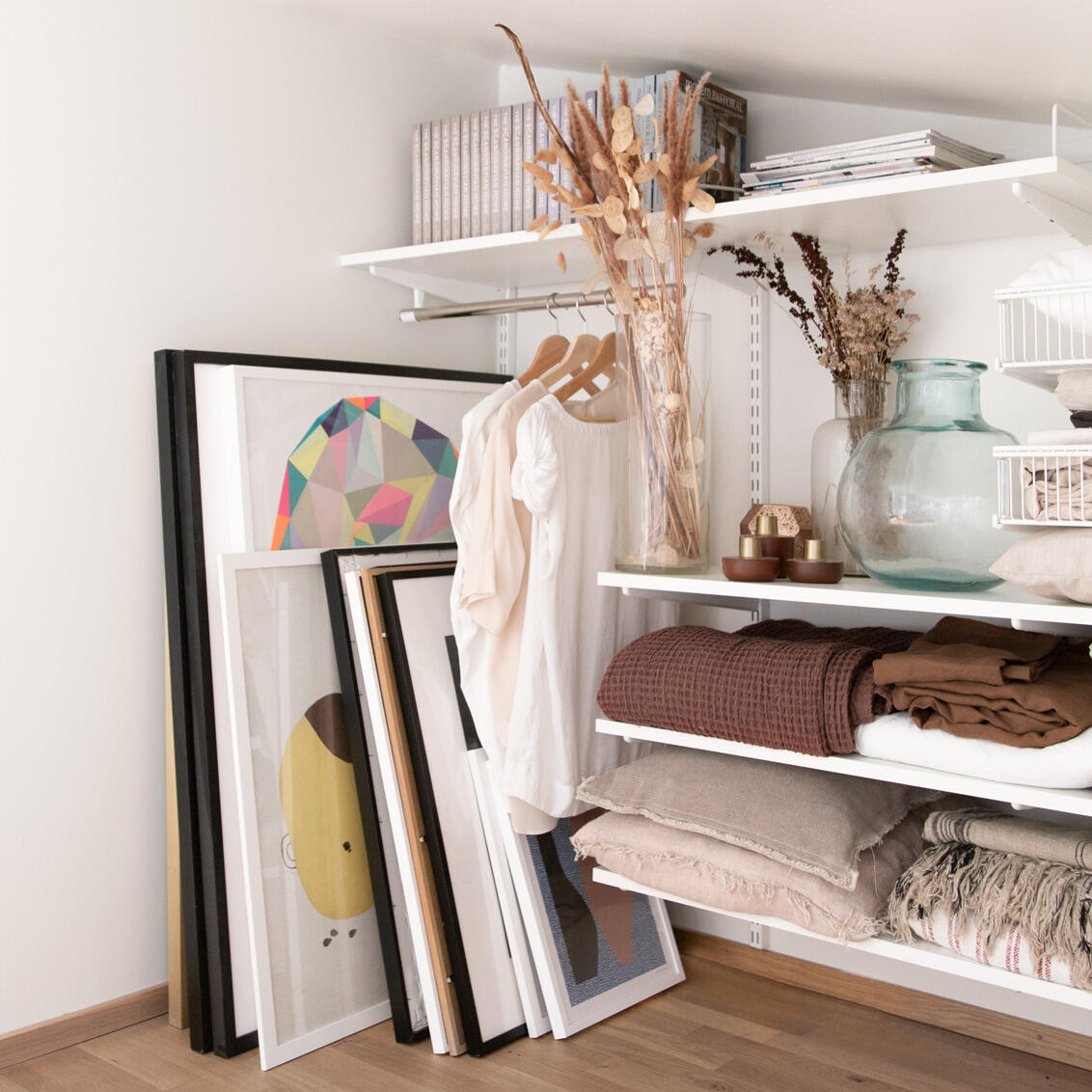 Almacenamiento en estantes, junto a él hay pinturas en el piso