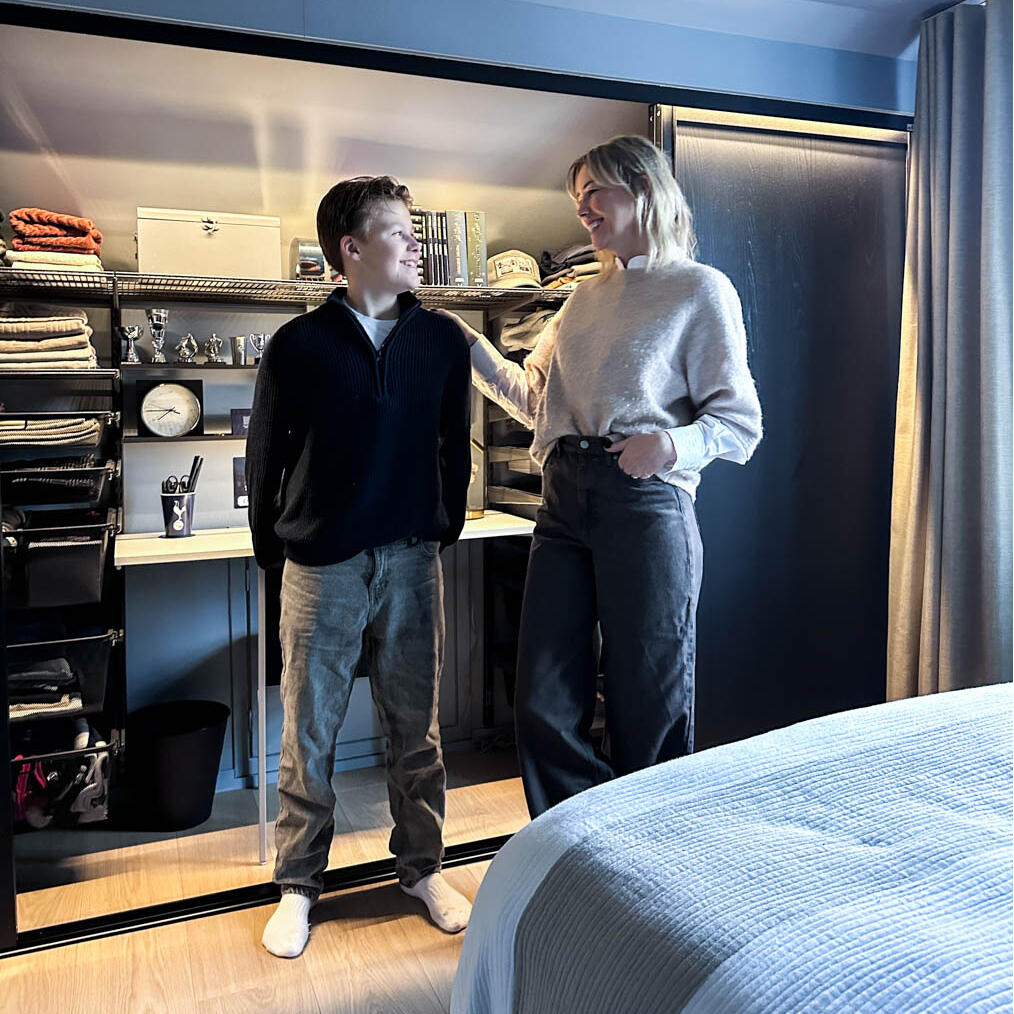 Charlie og Jannice i et teenageværelse med opbevaring og skydedøre i sort fra Elfa.