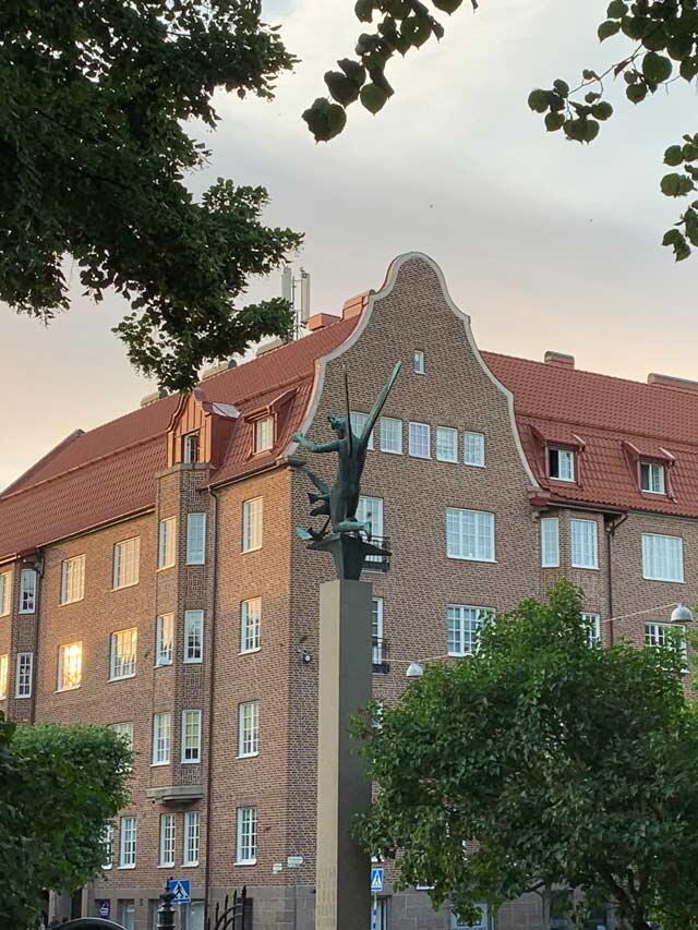 Ceglany budynek z czerwonym dachem i dekoracyjną rzeźbą o zmierzchu