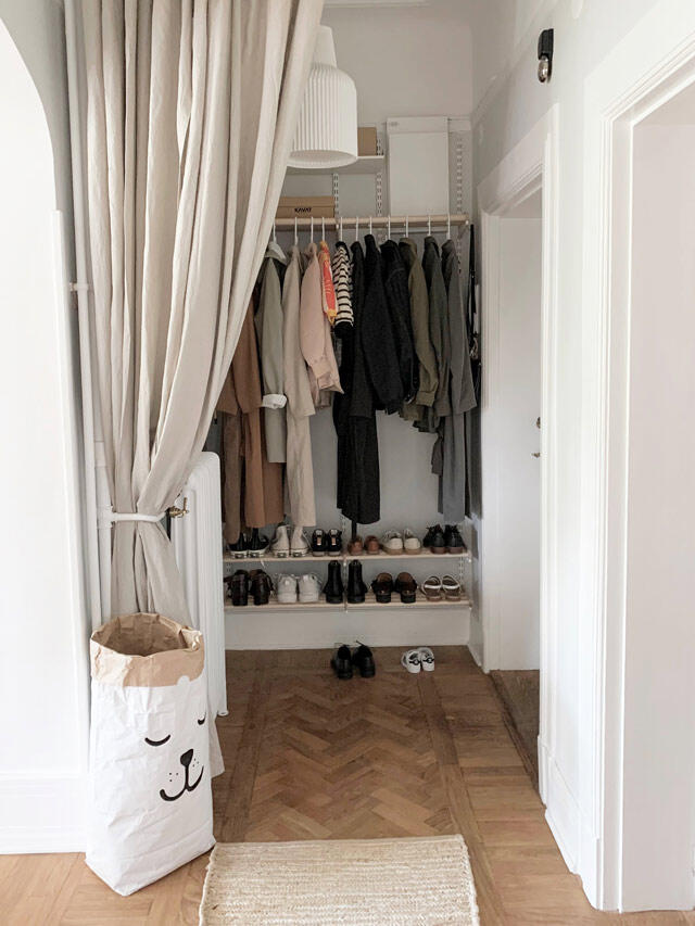System szaf Elfa z drążkiem na ubrania, półkami na buty i schowkiem za beżową zasłoną