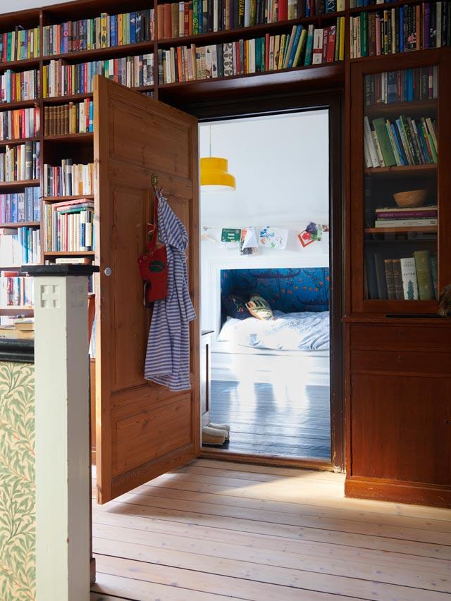 Bookcase with wooden frame before Elfa solution, with a view of the children's room through an open door