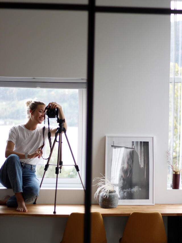Ingrid hobby i lustro robocze z aparatem na statywie przy oknie w jasnym pokoju z oprawioną sztuką