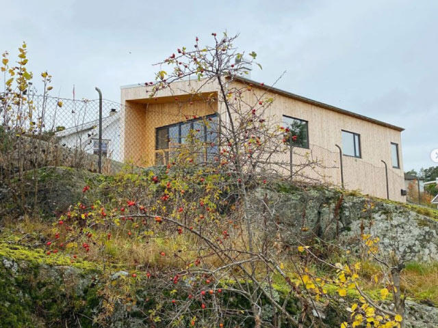 Modern wooden house on cliff before Elfa solution with autumn vegetation in the foreground