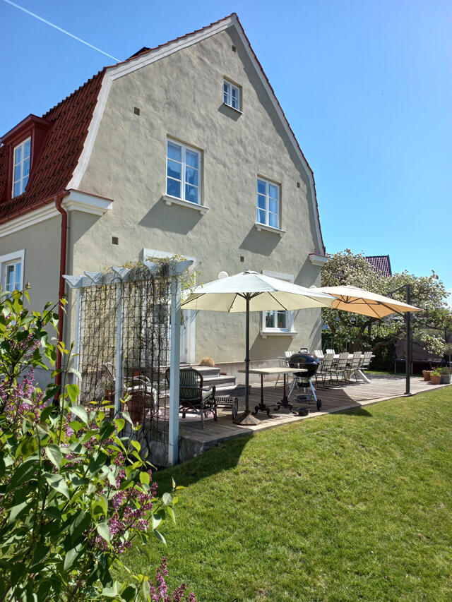 Patio White house with red roof and wooden decking