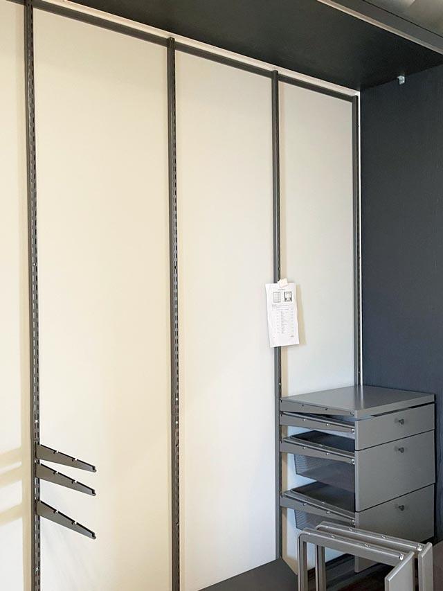 Stylish Elfa wardrobe with white sliding doors and built-in drawer storage