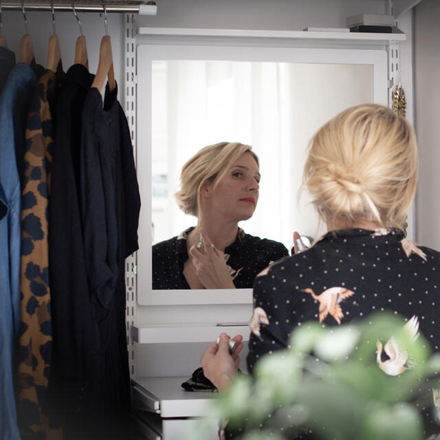 Elfa wardrobe system with integrated mirror and clothes rail in white finish