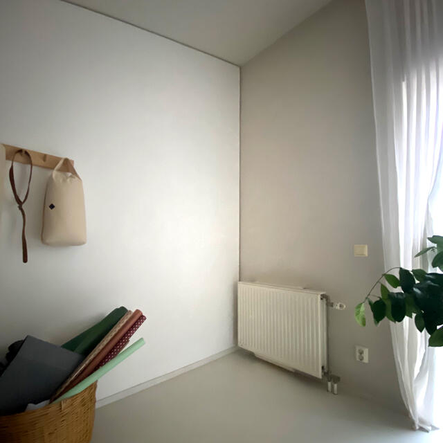 Niki Barntmark Minimalist white corner with wall hangers, radiators and thin curtains, before organizing