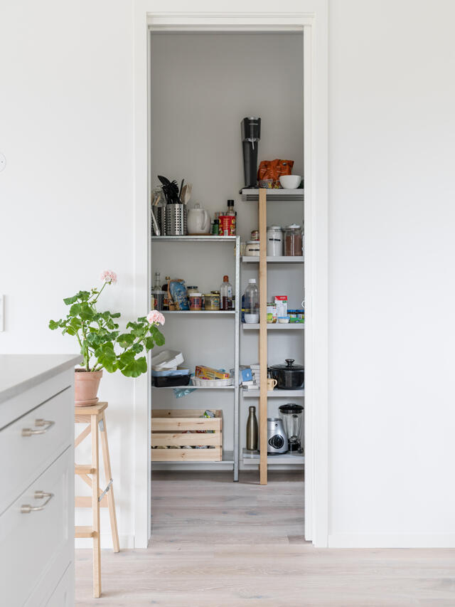 Cocina Cecilia M K con estantes metálicos sencillos, cajones de madera y suministros de cocina, necesita organización