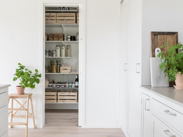 La cocina organizada de Cecilia M K con estantes Elfa llenos de productos enlatados y botellas