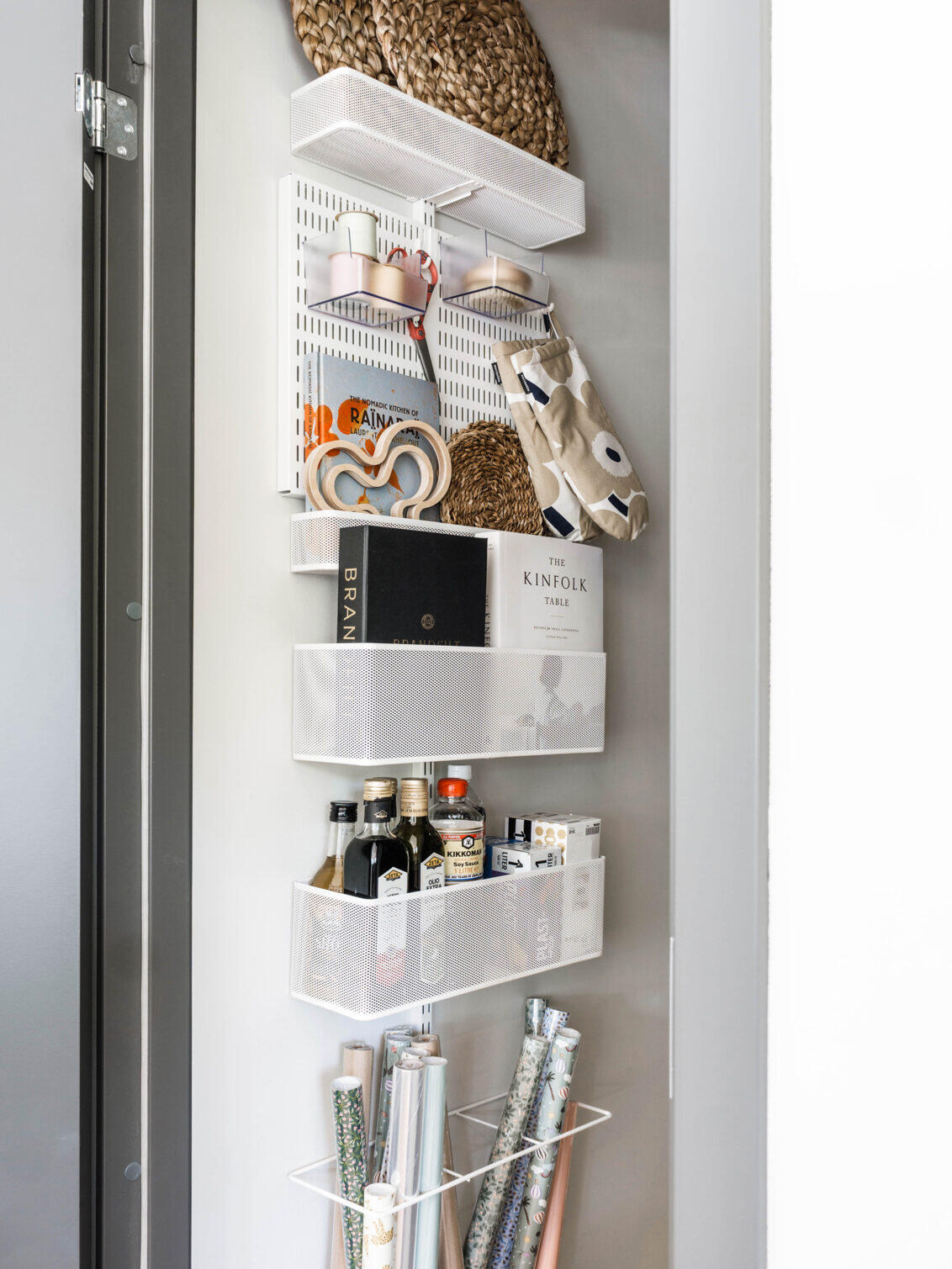 Elfa vertical storage solution with multiple wire baskets and gift wrapping paper storage