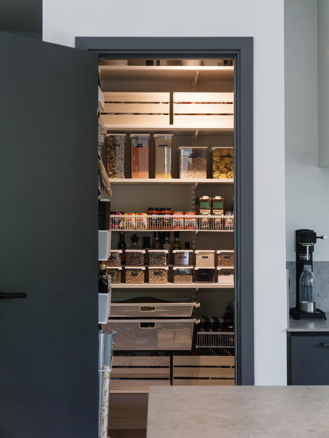 Elfa pantry with illuminated shelf lighting and organised storage containers