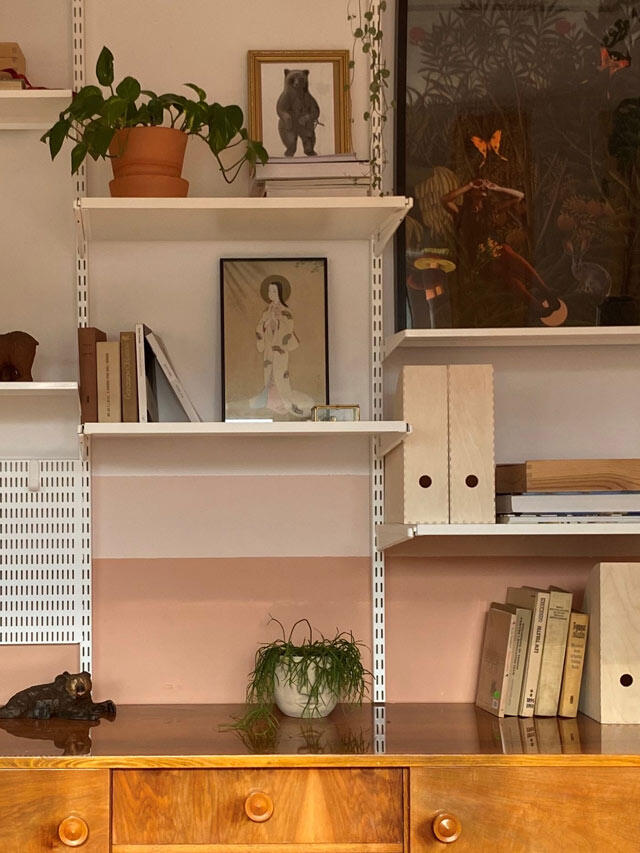 Elfa white shelving system with books and art exhibition