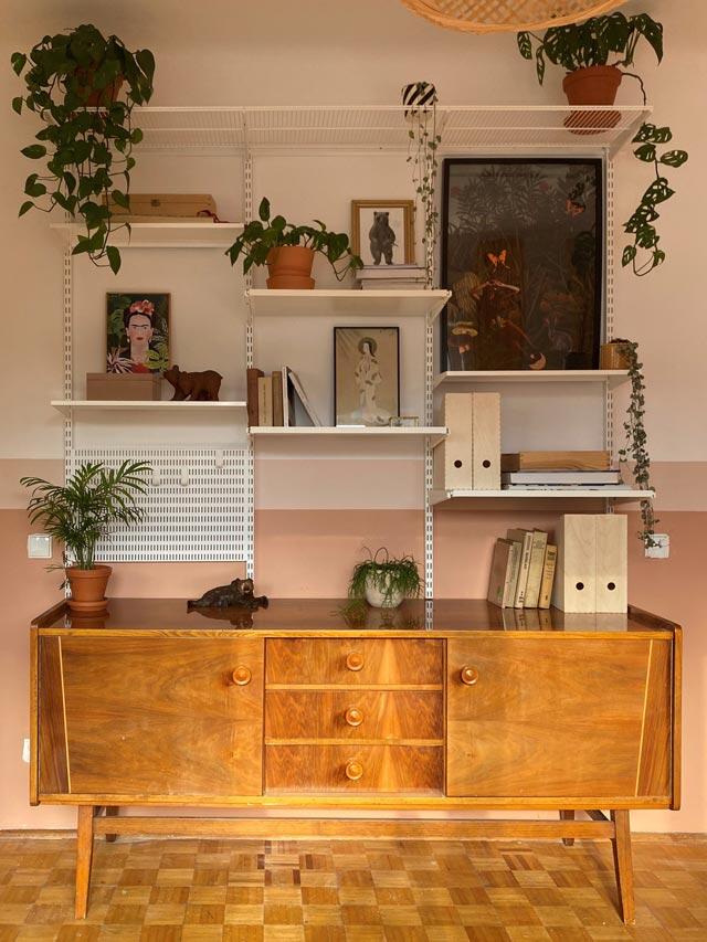 Elfa shelves above vintage wooden chest of drawers with plants