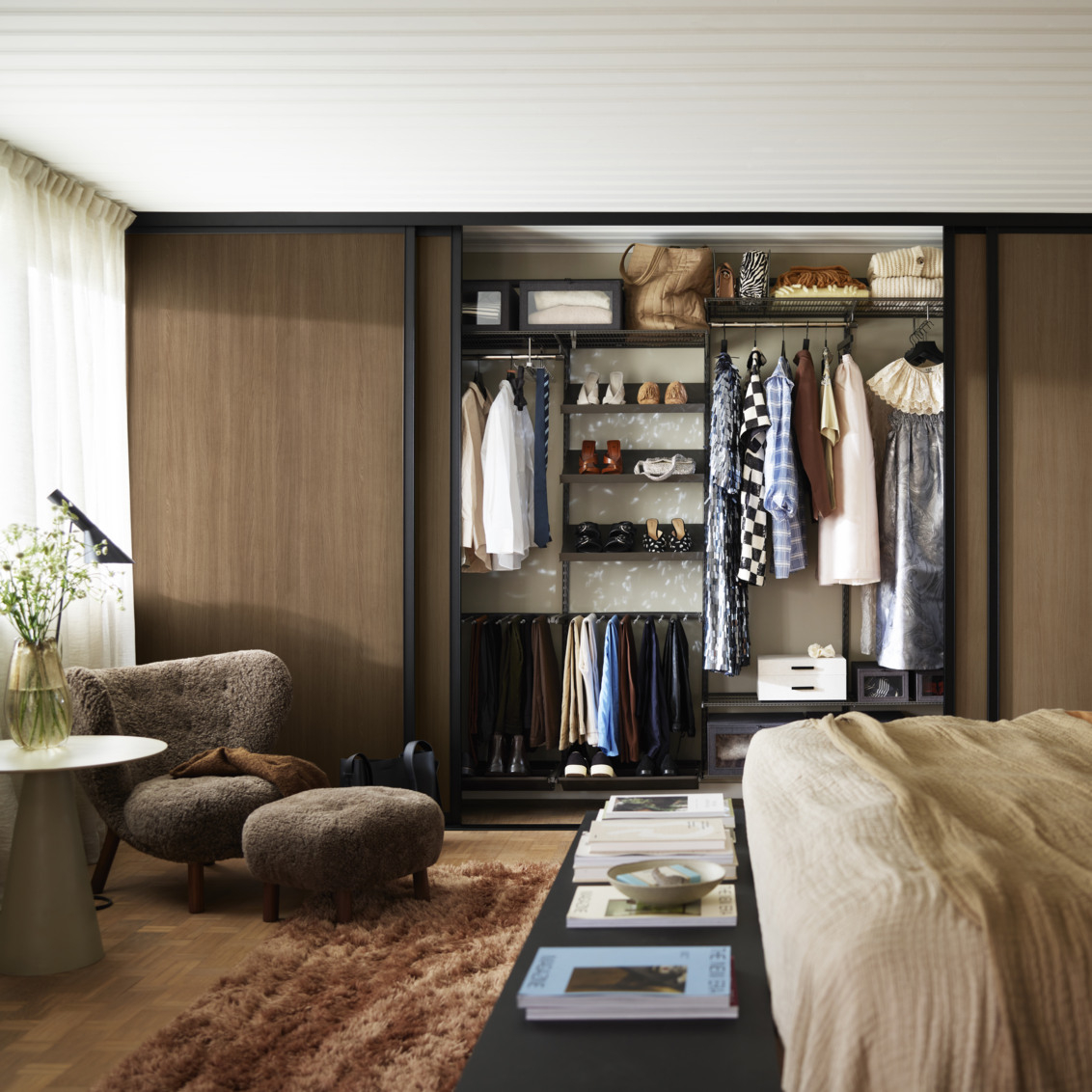 Makuuhuone, jossa on Elfa-vaatekaappi ja liukuovet, joiden täytteenä on tumma tammi.