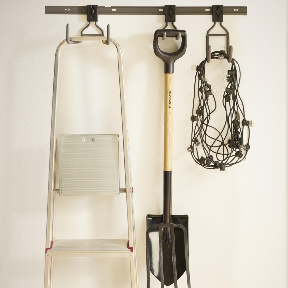 Garage+ storage track from Elfa with hooks for hanging items such as a ladder, spade or light chain. 